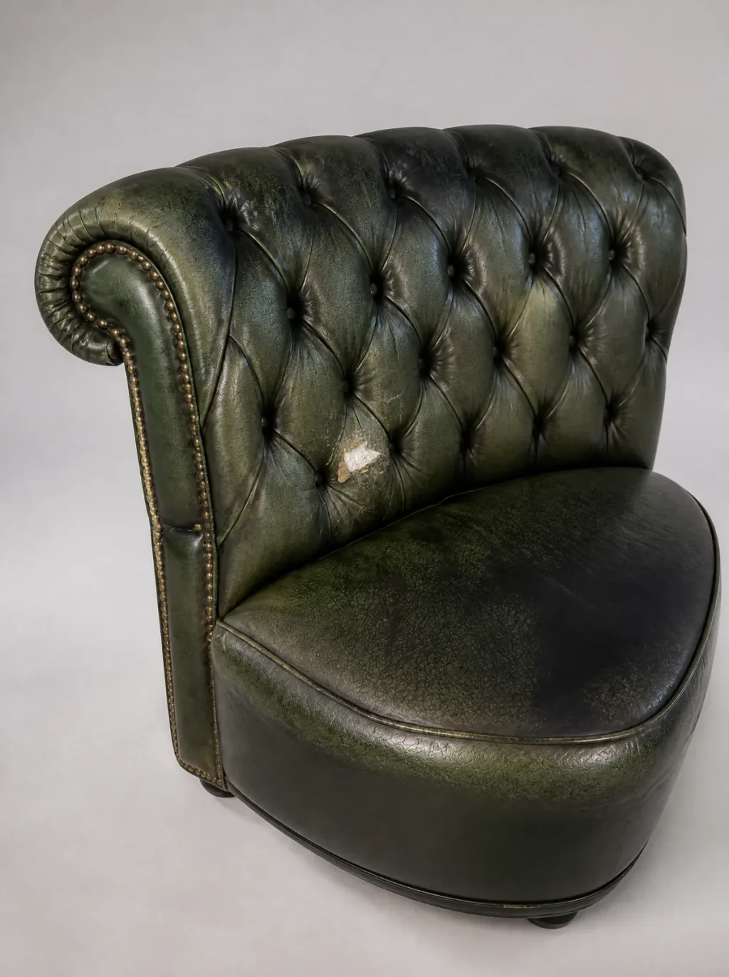 Aufgeriebenes Loch in der Kapitoné-Raute des grünen Chesterfield-Rückens | Chesterfield Polstergruppe Aufgeriebenes Loch in der Kapitoné-Raute des grünen Chesterfield-Rückens (Chesterfield Polstergruppe, Lederreparatur im Zürcher Oberland)