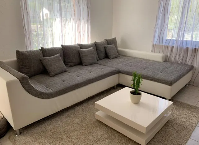 Das Ecksofa im Wohnraum: weisser Lederkorpus, graue Kissen, bodentiefer Aufbau | Ecksofa mit Ledersockel Aus der Polsterwerkstatt Egora: Das Ecksofa im Wohnraum: weisser Lederkorpus, graue Kissen, bodentiefer Aufbau (Ecksofa mit Ledersockel, Sofa neu beziehen)